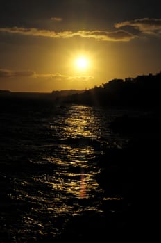 Silhouettes of Houses at Sunset over a Sea Village