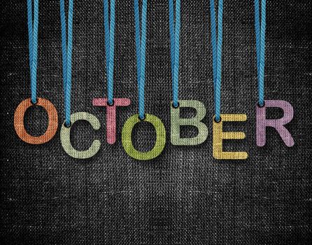 October letters hanging strings with blue sackcloth background.