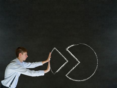 Sales businessman pushing chalk pie chart graph into place on blackboard background