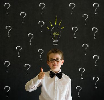 Thumbs up boy dressed up as business man questioning ideas on blackboard background