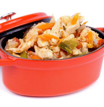 Homemade Chicken Breast Stew with Carrot, Leek and Bell Pepper in Orange Pot closeup on white background