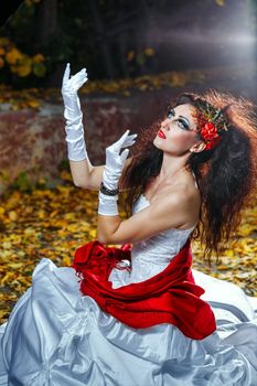 Attractive bride in a wedding dress with bright makeup, red shawl