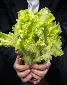 Healthy food. Man holding and eating lettuce
