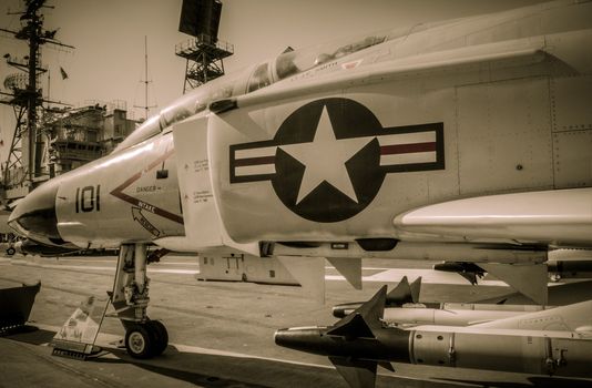 Jet with carrier tower in background San Diego USS Midway Deck