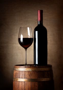 Wine standing on a barrel on a background of a canvas