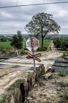 Warning sign worn of level crossing without barriers, blue sky with clouds