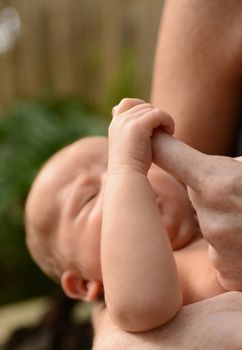 newborn infant or baby holding mother's finger on Mother's Day