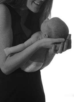 mom smiling at newborn infant and cradling baby in her arms