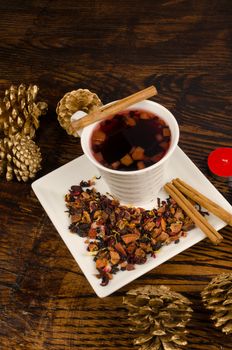 Hot fruity tea with cinammon sticks surrounded by Christmas decoration