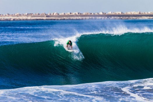 Surfer catching good size wave about to ride.