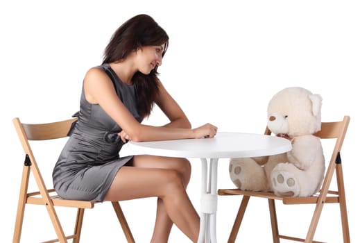 Young women looking at teddy bear isolated on the white