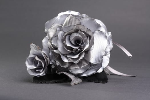 Artificial silver rose at grey background