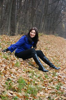 Young woman sitting in the autumn park