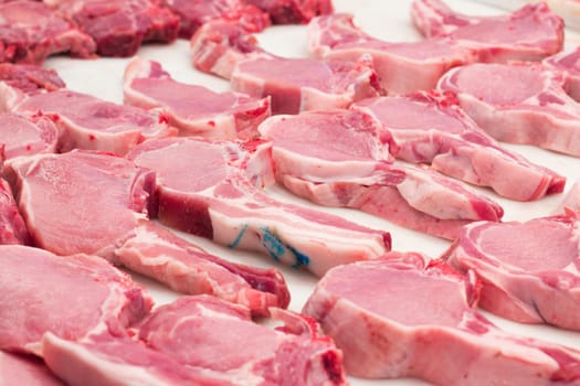 Fresh pork chops on a market stand.