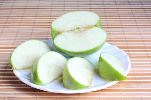 Apple pieces on the plate at the textured background