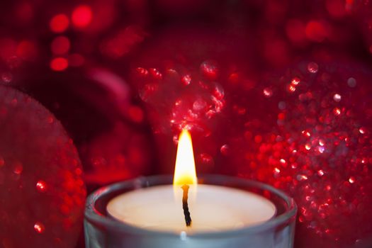 Close-up of christmas baubles and candle light