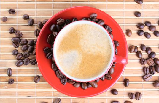 Cup of coffee with roasted beans at wooden background