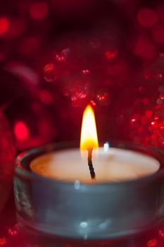 Close-up of christmas baubles and candle light