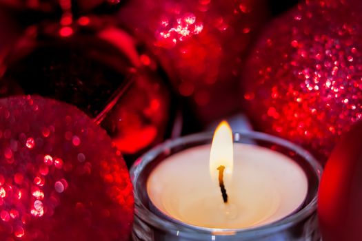 Close-up of christmas baubles and candle light