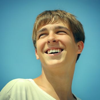 Toned photo of Cheerful Teenager Portrait on the blue sky background