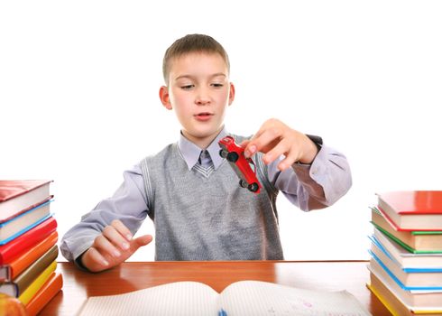 Schoolboy plays with a Toy on the School Desk on the white background