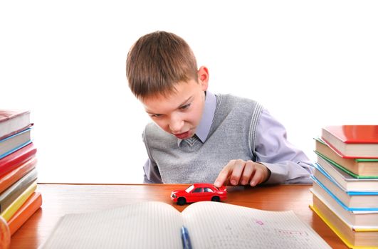 Schoolboy plays with a Toy on the School Desk on the white background