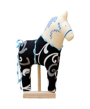 The Hand made soft toy horse isolated on black with blue on the stand