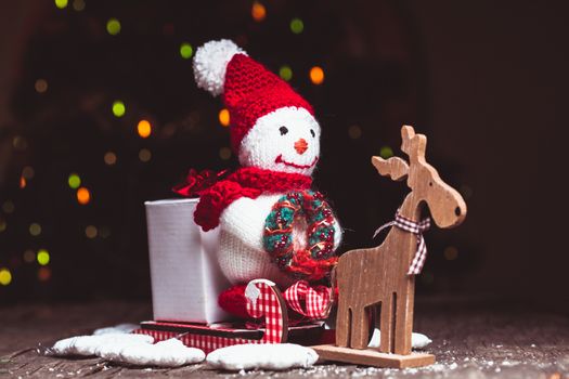 Knitted snowman on the sledges and gift box