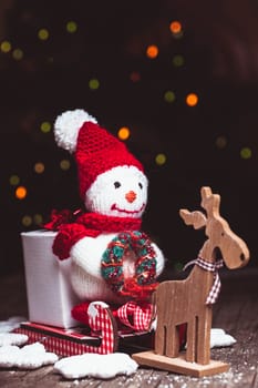 Knitted snowman on the sledges and gift box