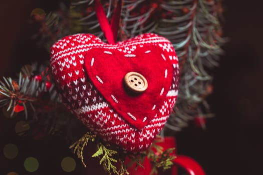 Handmade knitted heart - christmas decoration on the fir branch