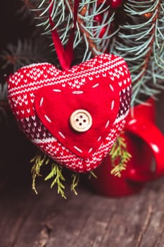 Handmade knitted heart - christmas decoration on the fir branch