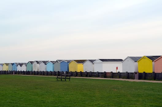 Row of coloured beach huts along the seafront at Worthing,Sussex,England.Image taken November 2013.