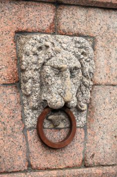 granite bas-relief of a lion's head on the quay