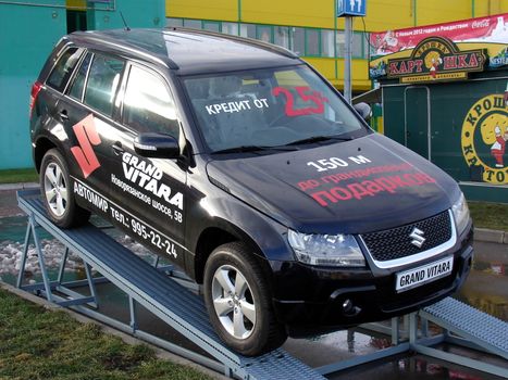 Black car Suzuki Grand Vitara on the stage