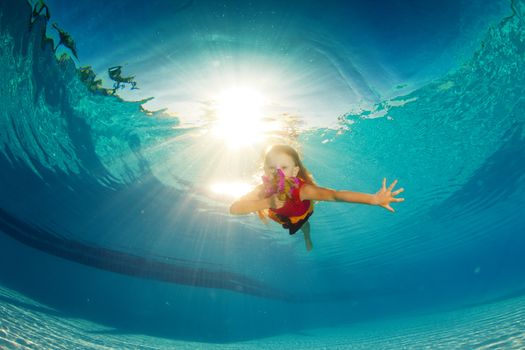 little girl underwater with bright flowers