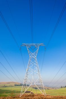 Electricity cables attached to steel structure towers transport electrical power supply over the countryside landscape