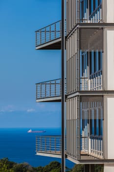 Blue Ocean Ship skies from building verandah balconies.