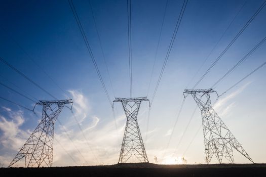 Electricity cables attached to steel structure towers transport electrical power supply over the countryside landscape