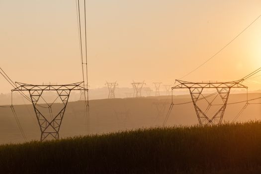 Electricity cables attached to steel structure towers transport electrical power supply over the countryside landscape