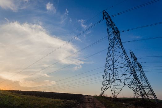 Electricity cables attached to steel structure towers transport electrical power supply over the countryside landscape