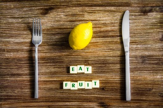 Silverware and apple on wooden vintage table with sign Eat fruit