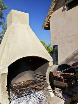 BBQ oven with chicken and meat on the fire