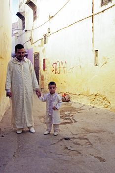 FES, MOROCCO - 15 OCTOBER 2013: Father and kid are dressed up for Eid Al-Adha. The festival is celebrated by offering a sheep and distributing the meat to relatives, friends and the poor