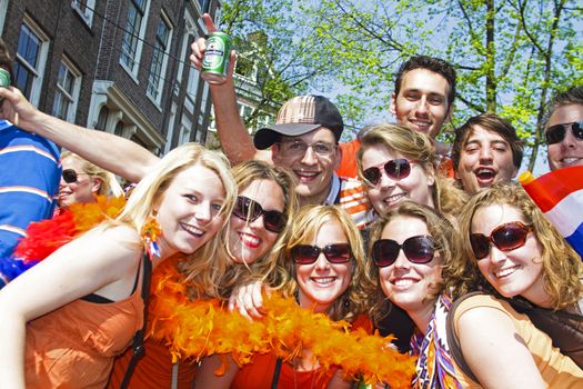 AMSTERDAM - APRIL 30: Group of friends in orange partying at the celebration of queensday on April 30, 2011 in Amsterdam, The Netherlands
