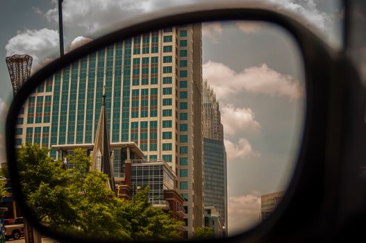 buildings seen in side mirror of car