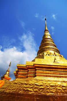 Golden Pagoda with blue sky at temple in Thailand