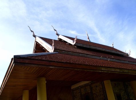 Roof of old temple with blue sky in Thailand