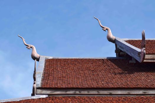 Roof of old temple with blue sky in Thailand