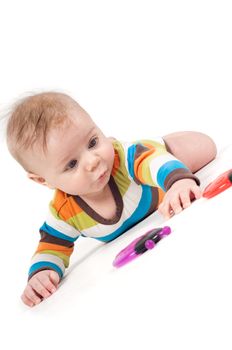 Cute kid in a striped body lying on his tummy with toys