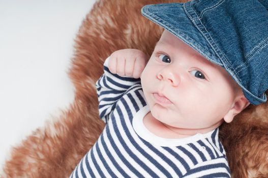 Shot of newborn baby lying on fur in hat